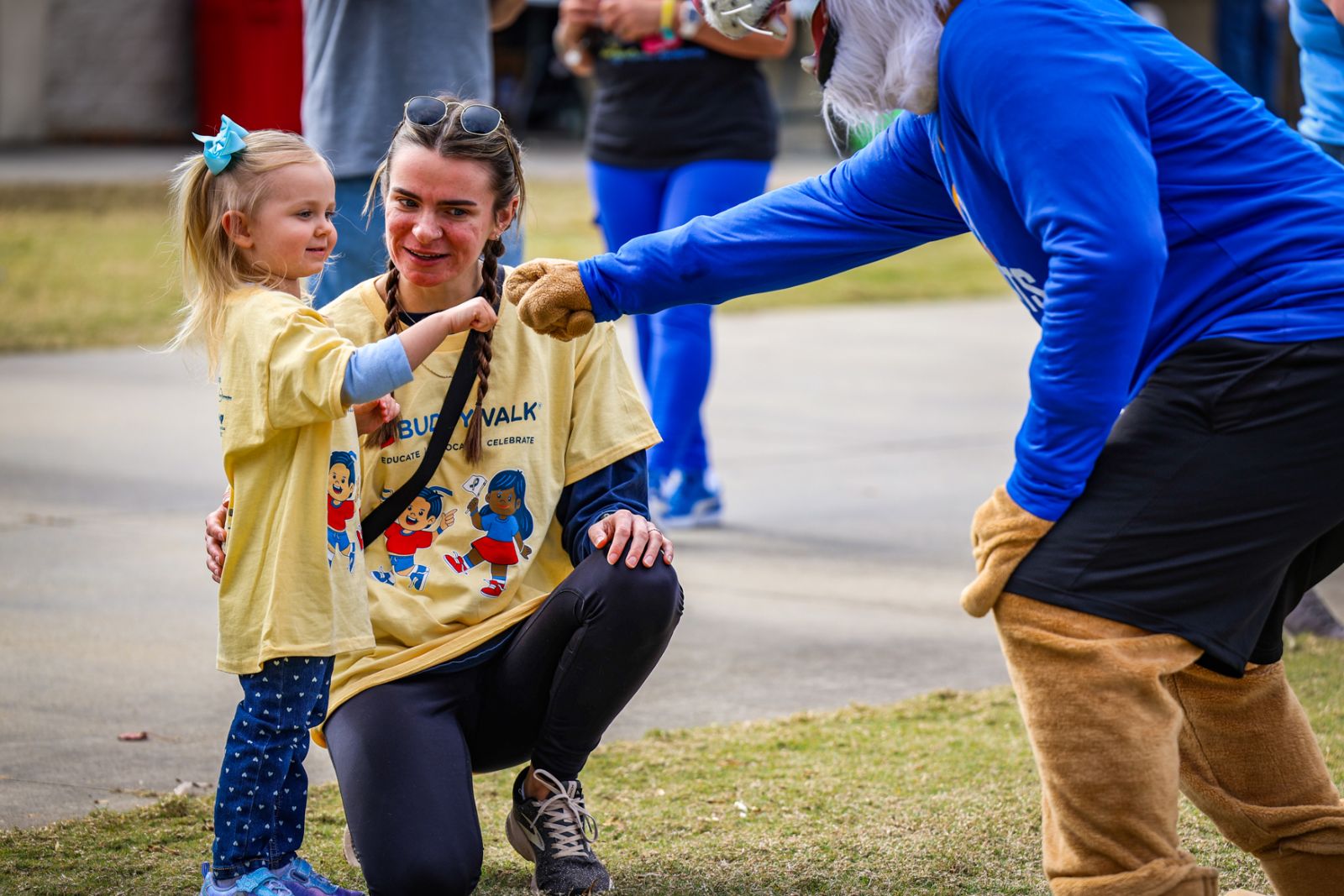 Young child fistbumping an adult.